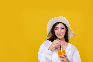 Portrait Asian beautiful happy young woman with sunglasses  smiling cheerful and Holding a glass of orange juice in summer and looking at camera isolated on yellow studio background.