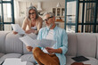 © gstockstudio - Modern senior couple in casual clothing taking care of their finances while bonding together at home