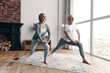 © gstockstudio - Good looking senior couple in sports clothing exercising and smiling while spending time at home