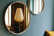 © VISUALSPECTRUM/Stocksy - Retro Interior Design - Round Mirrors and Lamp