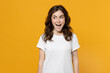 Young surprised shocked excited impressed amazed fun eueropean caucasian student woman 20s wearing white basic casual t-shirt looking aside isolated on yellow orange color background studio portrait.