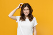 © ViDi Studio - Young pensive thoughtful overthink mistaken troubled eueropean caucasian student woman 20s in white basic casual tshirt look aside sctratch head put hand isolated on yellow background studio portrait