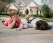 © Jakob Lagerstedt/Stocksy - A young boy and his sister taking a break from playing on the driveway