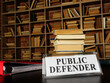 Nameplate public defender and stack of book.