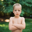 © Jakob Lagerstedt/Stocksy - Cute young boy with no shirt pretending to look tough
