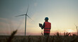 © Videophilia Stock/Stocksy - Engineer checking windmill farm system