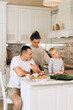 © Alina Hvostikova/Stocksy - Happy family having lunch in kitchen