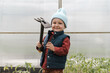© Alina Hvostikova/Stocksy - Cute boy with hoe in greenhouse