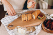 © Alina Hvostikova/Stocksy - Crop woman cutting bread for sandwiches