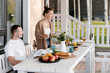 © Alina Hvostikova/Stocksy - Happy couple having lunch on veranda