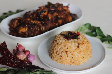 Sticker - Cooked rice tossed in pan used for cooking chicken with the left over chicken gravy. The rice appearing in red colour.