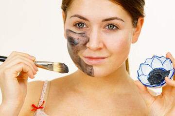 Woman being apply black carbo mask to face