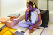 © BONNINSTUDIO/Stocksy - Ethnic student eating pizza near laptop