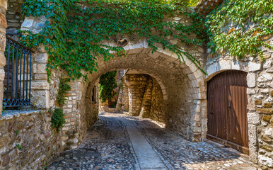 A medieval alley under a stone bridge in an old village in Italy