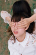 © Pansfun Images/Stocksy - Two fashionable women covering eyes with hands