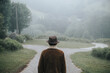 © Hakan & Sophie/Stocksy - Anonymous man at a crossroads on a foggy day