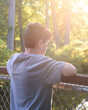 © Angela Waye/Stocksy - Boy Outside Watching Sunset by Fence