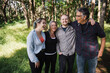 © Rob and Julia Campbell/Stocksy - Happy family of four with older kids enjoying time outside in na