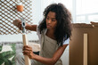© David Prado/Stocksy - Positive woman assembling table at home