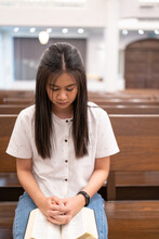 Asian Woman Is Reading The Holy Bible And Praying In A Christian Church.