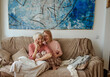 © Tatiana Timofeeva/Stocksy - Active age ageless senior woman with daughter on house sofa
