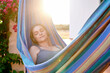 © Ivan Gener/Stocksy - Woman relaxing to music in a hammock