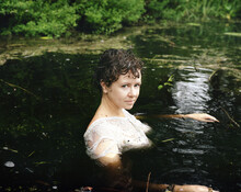 Young Woman Swimming In Pond