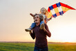© Sergey Narevskih/Stocksy - Father and kid having fun with kite in field