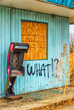 What is left of  a payphone by an abandoned motel.