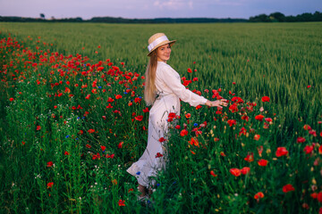 Wall Mural - young woman in long white dress and boater posing in the field w