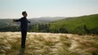 © Dmitry Borovikov/Stocksy - The guy enjoys the wind in the feather grass field.