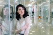 © Alex Li - Brunette girl wearing white designer dress is reflected in the glass showcase. Look away from the camera.