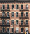 Old tenement house building with fire escapes, color toned picture, New York City, USA.