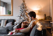 © Milles Studio/Stocksy - Happy diverse couple lounging on couch on Christmas eve