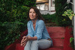 © Rob and Julia Campbell/Stocksy - Mature woman sitting and casual in neighborhood.
