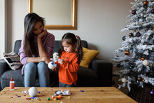 Mother And Daughter Making Christmas Baubles