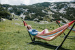 © Ksenia Krondo/Stocksy - Girl in the hammock at the mountains resting smiling