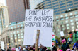 © Holly Clark/Stocksy - Sign held up in a crowd at a Rally