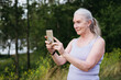 © Irina Polonina/Stocksy - Senior woman takes selfies with a smartphone.