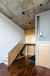© Luciano Spinelli/Stocksy - Staircase in a loft painted in gray with concrete ceiling and wood floor