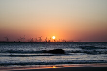 Sunset In The Sea With Windmills