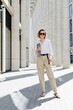 © Sergey Narevskih/Stocksy - Smart woman with laptop standing on street near business center