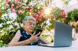 © MyMicrostock/Stocksy - Happy elderly woman on videocall using a modern laptop