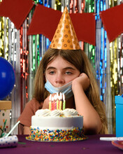 Sad Girl Child Wearing Face Mask Looking At Birthday Cake