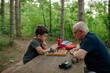 © AD Photography/Stocksy - Grandfather playing chess with his grandson