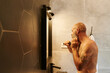 © Ivan Gener/Stocksy - Mature man styling his beard in a mirror