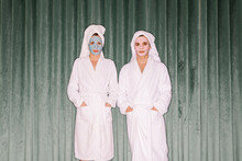 Couple Wearing Bath Robes In Front Of A Green Velvet Curtain
