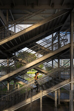 Asian Woman Exercising Outdoors Running Up A Steel Staircase