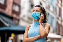 Woman Wearing Face Mask Using Phone