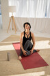© Sibstock/Stocksy - woman resting on yoga mat after sports